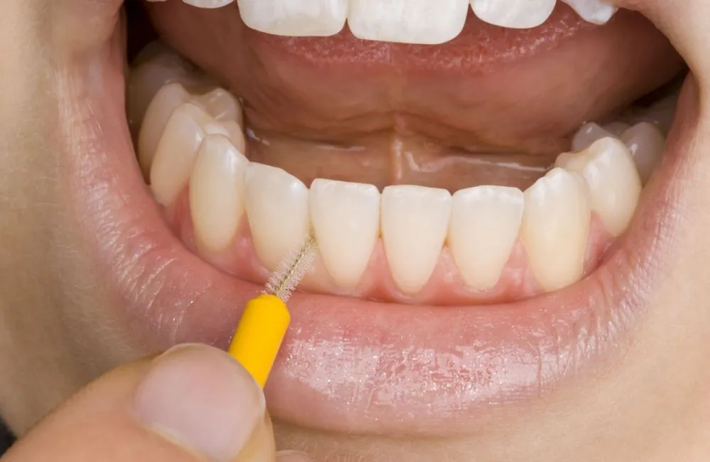 Adult using interdental brushes and practising daily habits that help protect gum health